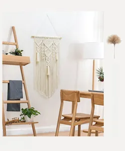 Detail of bohemian handmade cotton woven tapestry with geometric fringe and wooden dowel