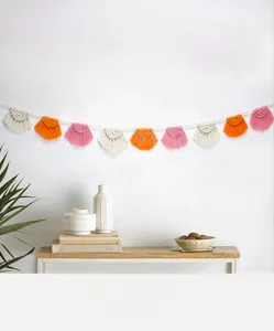 Dettaglio della ghirlanda di nappe in cotone bohémien con mezzelune crema arancio e rosa