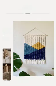 Detailed macro view of woven wall tapestry featuring mountain pattern and tassel fringes