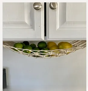 Detail of hand-woven cotton rope fruit hammock mounted under a kitchen cabinet