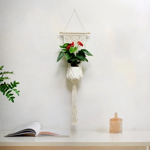 Detail of handwoven cotton rope plant hanger with wooden rod and bohemian tassels decoration