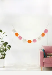 Dettaglio di frange bohémien in cotone fatte a mano con nappe bianche arancioni e rosa