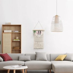 Detail of bohemian macrame wall hanging organizer with tassel fringe and wooden support