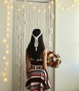 Detail van de bohemian witte macramé hoofdband met geweven textuur en lange franjes