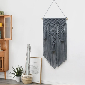 Handmade dark gray macrame wall hanging with geometric patterns and long fringes