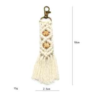 Macro shot showing 18cm bohemian macrame keychain with beige cotton rope and wooden beads