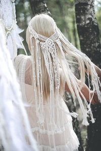 Detail van handgemaakte witte Macramé hoofdband van katoen met lange franjes in boho-stijl