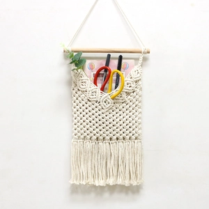 Handwoven macrame wall hanging storage pocket with boho tassels and wooden stick