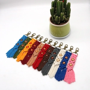 Set of 11 colorful boho macrame keychains with fringe and beads on white background