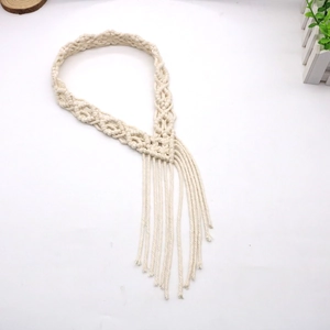 Detail van een bohemien crème macramé hoofdband met franjes en handgeweven knopen