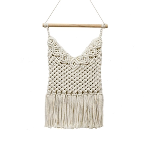 Handwoven bohemian wall hanging with white cotton tassels and a wooden pole for home decor