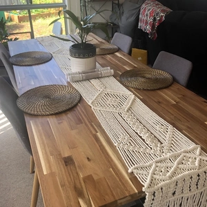 Detailed macro view of handmade macrame table runner with boho fringe and woven patterns