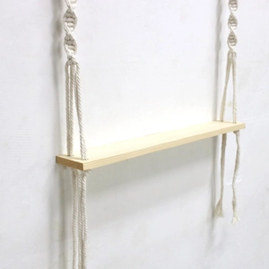 Detail of Nordic woven pet swing with wooden shelf and handmade macrame cotton ropes
