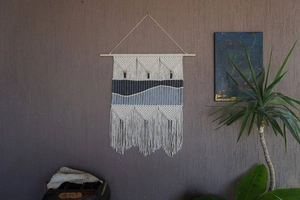 Detailed close-up of Bohemian macramé wall hanging with navy and grey woven textures