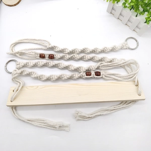 Detailed view of handmade bohemian cotton rope pet swing with wooden shelf and beads