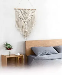 Detail of macrame wall hanging featuring hand-woven cotton patterns and tassels in bedroom