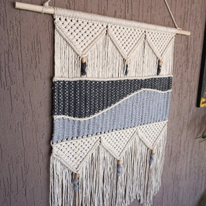 Detail of bohemian hand-woven tapestry with geometric textures and tassel fringe