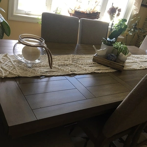 Handmade macrame table runner in cream cotton on a dark wood dining table decoration