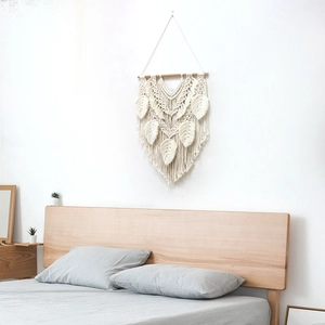 Boho macrame wall hanging with handmade cotton feather leaves on a wooden rod for home decor