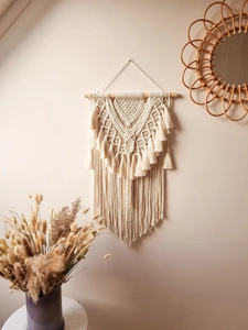 Macro detail of handmade macrame wall hanging featuring intricate geometric knots and fringes
