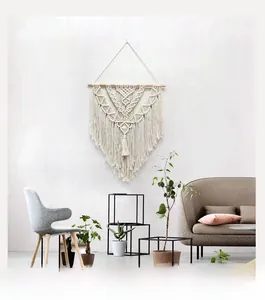 Detail of hand-woven macrame wall hanging with V-shaped textures and cotton tassels