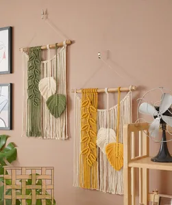 Detailaufnahme von handgefertigtem Makramee-Wandteppich mit olivgrünen und gelben Blättern