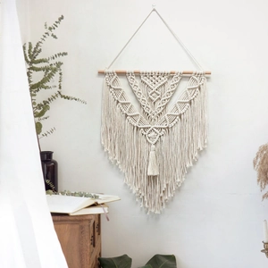 Handmade macrame wall hanging with boho fringe design and wooden rod for home decor