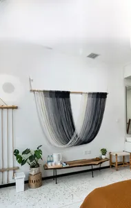 Detail of Nordic macrame wall hanging with grey and blue gradient fringe and wood pole