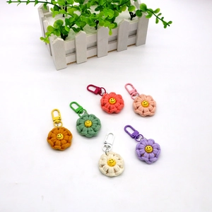 Detailed overhead view of six colorful handmade crochet flower keychains with smiley centers