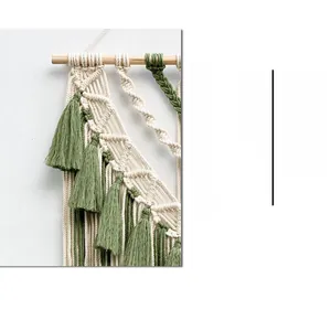 Close-up of handmade bohemian tapestry featuring cotton tassels and forest green weaving