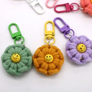 Close-up of handmade cotton rope woven flower keychains with cartoon smiley face beads