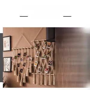 Détail d'un porte-photos mural en macramé de coton fait main avec franges et pinces en bois