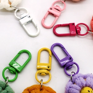 Close-up of colorful painted metal lobster clasps with handmade woven flower pendants