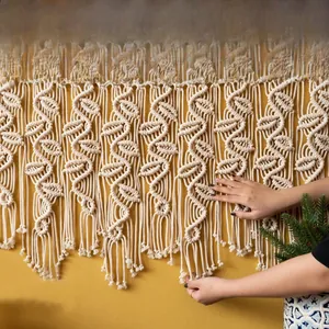 Gros plan d'une tapisserie bohème tissée main avec textures de coton en spirale et pompons