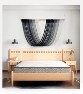 Detail of V-shaped gradient gray handmade woven tapestry on a wooden pole for wall decor