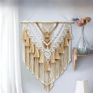 Detail of hand-woven macrame wall hanging with boho fringe on a natural wooden pole