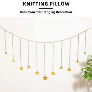 Close-up of golden bohemian wall decor featuring multiple hanging star pendants