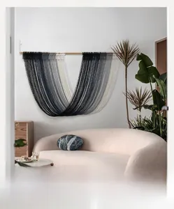 Detail of handcrafted Nordic gray gradient macrame wall hanging with woven fringe textures