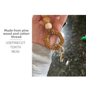 Detail of handmade lanyard featuring natural pine wood beads and a woven rattan hexagon ring