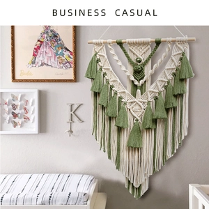 Detail of handmade macrame wall hanging with sage green tassels and wood pole