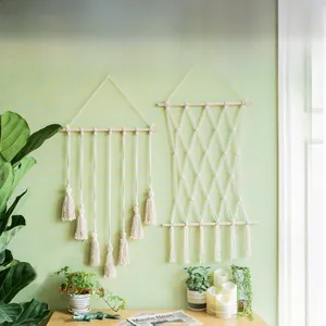 Détail de décoration murale boho nordique avec corde en coton tissé et pompons à franges
