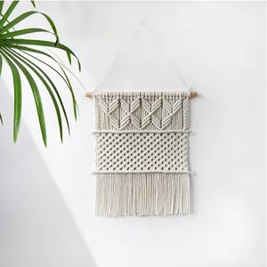 Vue détaillée de la tapisserie bohème en coton faite à main avec pompons élégants