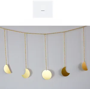 Detailed view of Nordic gold metal moon phase wall hanging with five moon cycle pendants