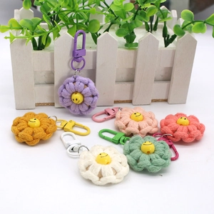 Close-up of hand-woven cotton flower keychains with colorful carabiners and smiley faces