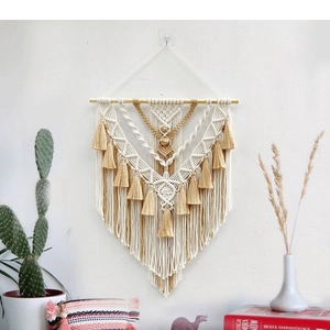 Detailed close-up of handmade bohemian woven tapestry with tassels and geometric knots