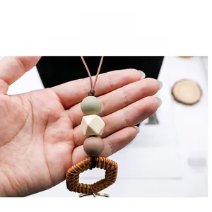 Detail of handmade lanyard with silicone beads and a natural woven rattan ring pendant