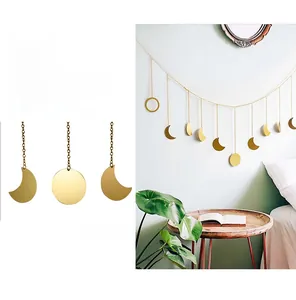 Detail view of moon phase wall hanging with golden metal discs and chains in Nordic style
