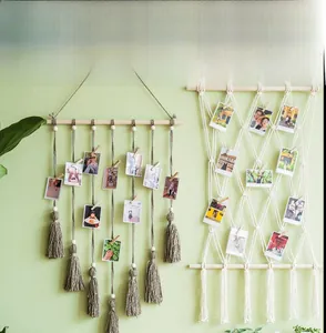 Détail de la décoration murale bohème avec pompons en coton et pinces en bois