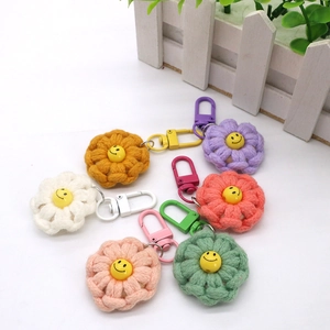 Macro detail of handmade woven flower keychains with colorful petals and smiley faces