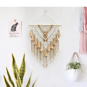Detail of bohemian hand-woven tapestry with fringe accents and a natural wood rod